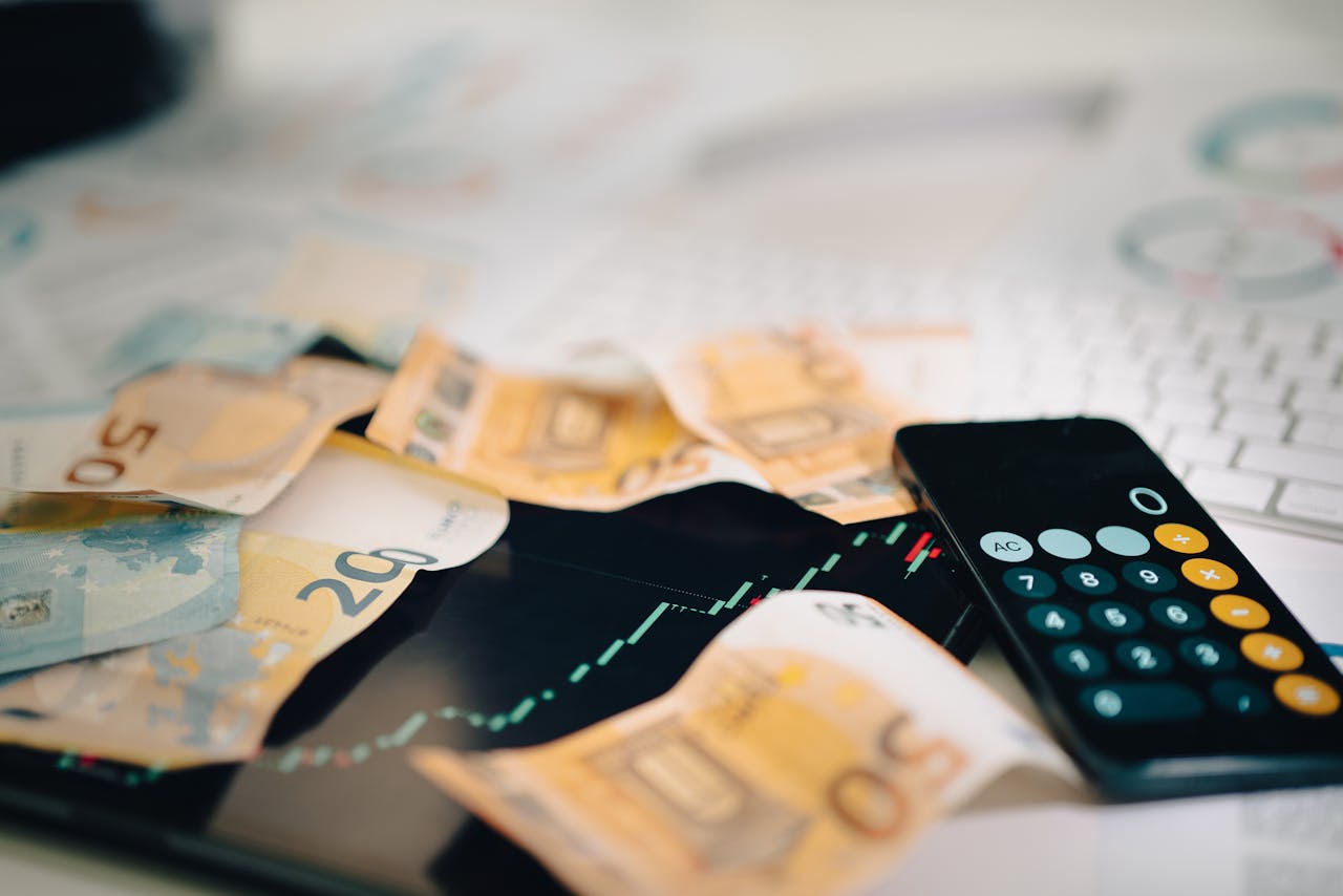 ours-journey Euro banknotes scattered on a trading chart with a calculator, symbolizing finance and analysis.